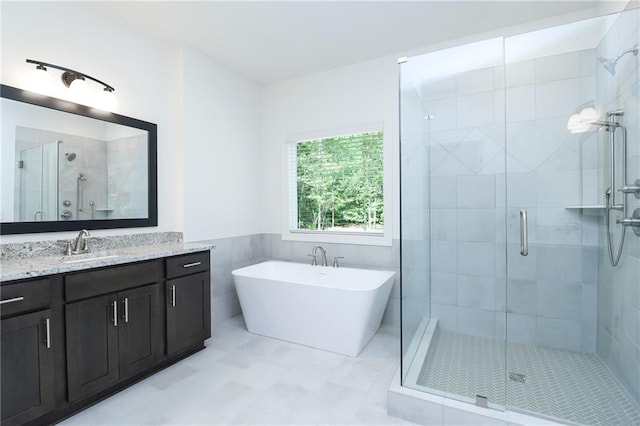 2113 Ella Springs Dr, Covington, GA 30014 - bathroom featuring a shower stall, vanity, a freestanding bath, and tile walls