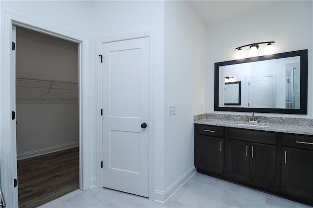2113 Ella Springs Dr, Covington, GA 30014 - bathroom featuring vanity, baseboards, a walk in closet, and marble look tiles