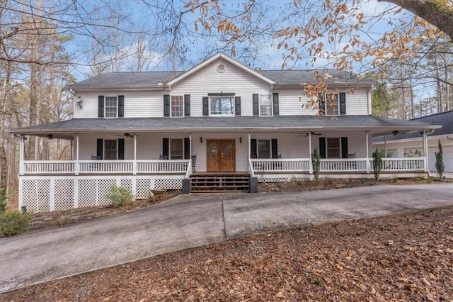 country-style home with driveway and a porch