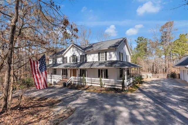 farmhouse featuring driveway and covered porch