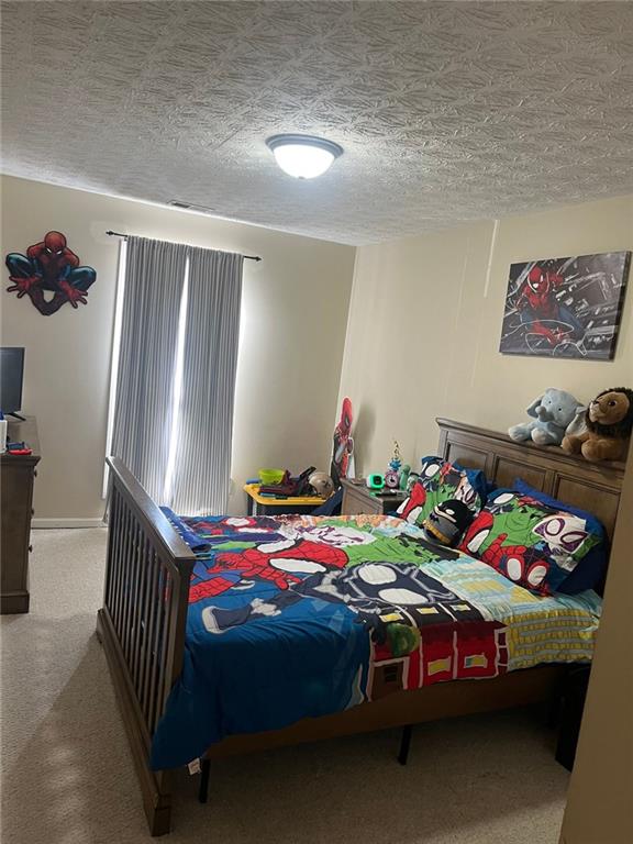 bedroom featuring carpet floors and a textured ceiling