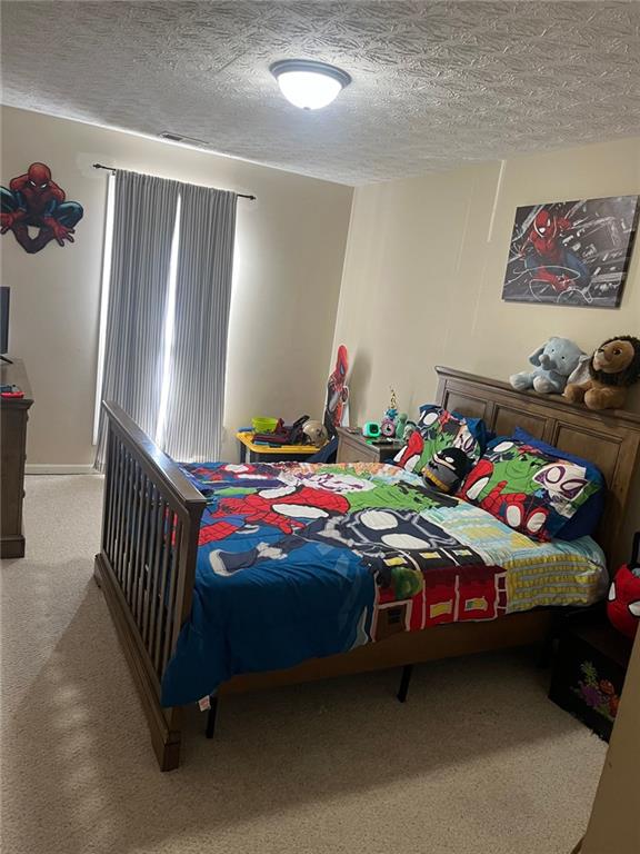 carpeted bedroom featuring a textured ceiling