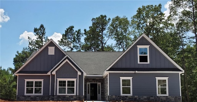 craftsman inspired home with board and batten siding, stone siding, and roof with shingles