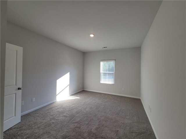 unfurnished room featuring carpet and baseboards