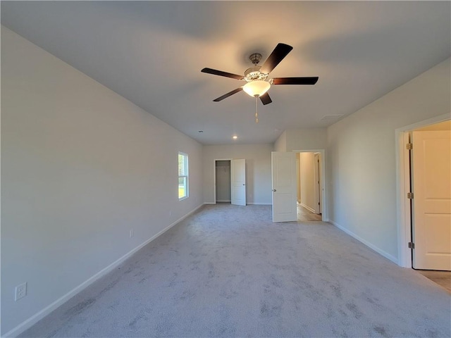 unfurnished bedroom featuring light carpet, baseboards, and a ceiling fan