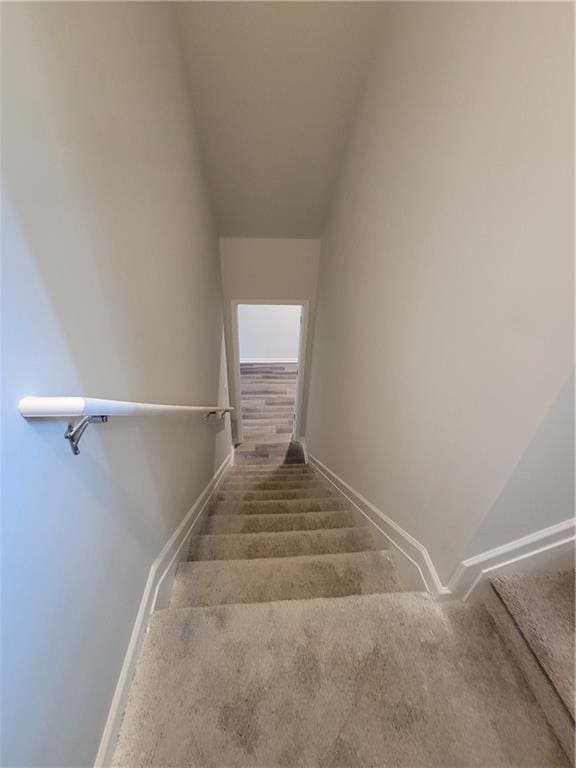 stairs featuring carpet floors and baseboards