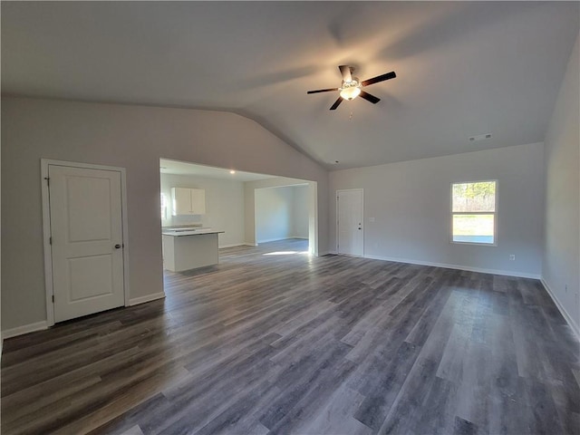 unfurnished living room featuring ceiling fan, vaulted ceiling, dark wood-style floors, and visible vents