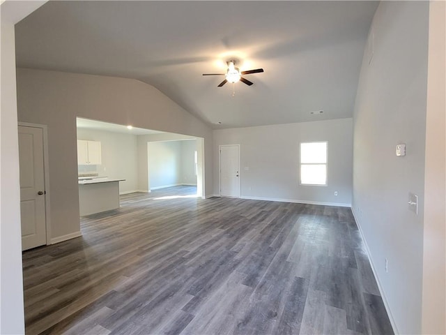 unfurnished living room featuring lofted ceiling, ceiling fan, baseboards, and dark wood-style flooring