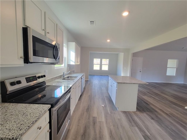 kitchen featuring stainless steel appliances, open floor plan, visible vents, and a sink