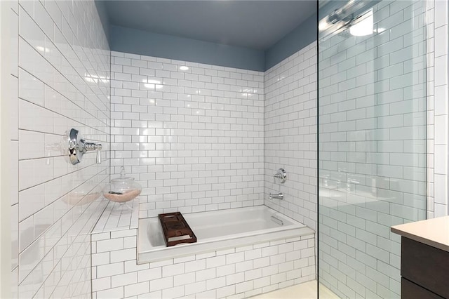 bathroom featuring tiled shower / bath and vanity