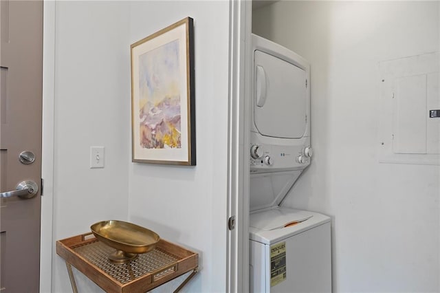 laundry area featuring electric panel and stacked washer / drying machine