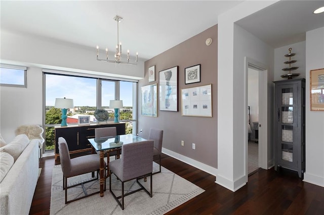 dining room with dark wood-type flooring and a notable chandelier