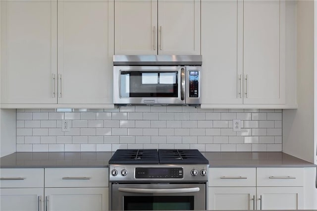 kitchen featuring stainless steel appliances, white cabinets, and tasteful backsplash