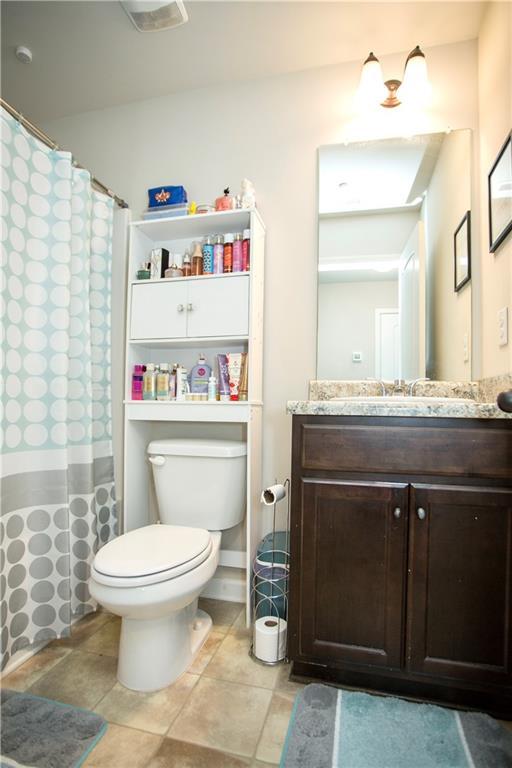 carpeted bedroom featuring baseboards, multiple windows, visible vents, and a ceiling fan