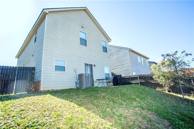 back of property with a fenced backyard, cooling unit, and a lawn