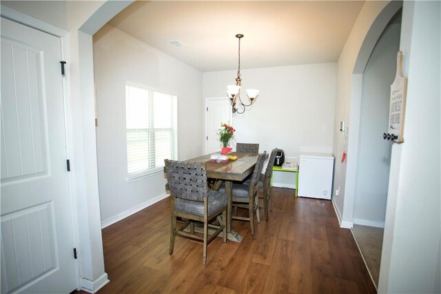 kitchen with white cabinets, light wood-style flooring, arched walkways, and stainless steel appliances