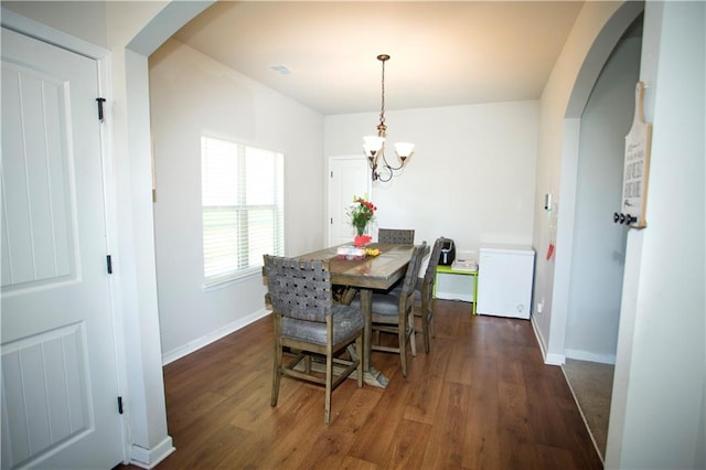 dining space featuring visible vents, baseboards, arched walkways, wood finished floors, and a notable chandelier