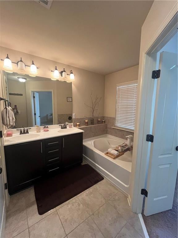 bathroom featuring tile patterned flooring, a garden tub, a sink, and double vanity