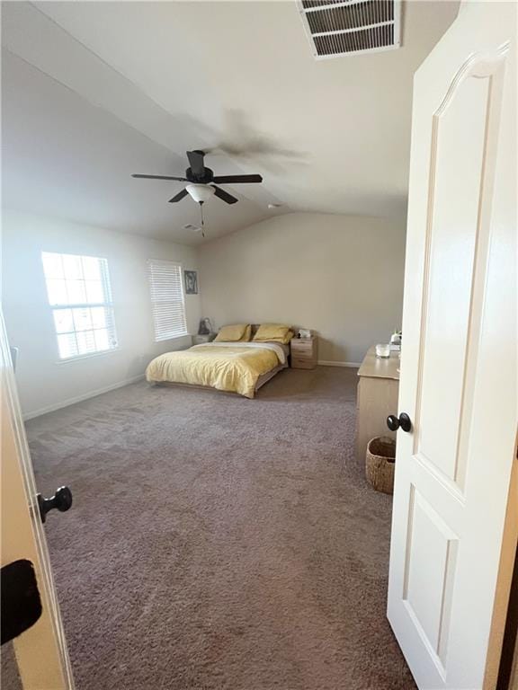 carpeted bedroom with baseboards, visible vents, vaulted ceiling, and a ceiling fan