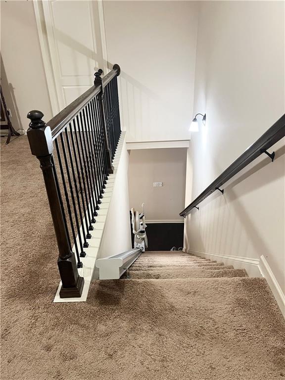 stairway featuring carpet and a towering ceiling