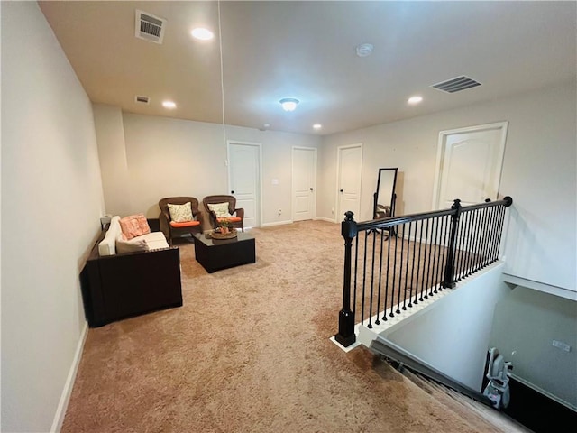 interior space with an upstairs landing, recessed lighting, visible vents, and carpet flooring