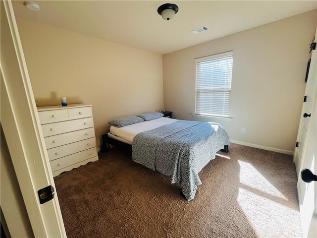 bedroom with dark colored carpet, visible vents, and baseboards