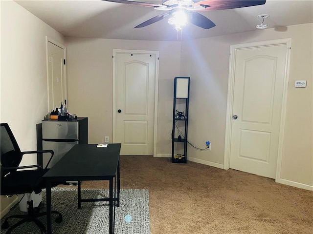 carpeted home office featuring a ceiling fan and baseboards