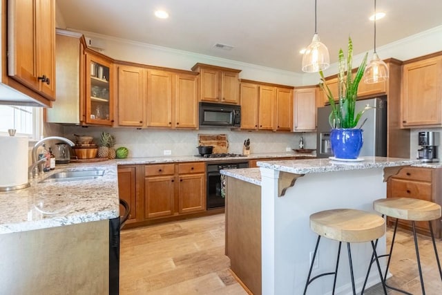 6426 Queens Court Trce Unit 7, Mableton, GA 30126 - kitchen featuring black appliances, a breakfast bar area, light stone counters, a center island, and crown molding