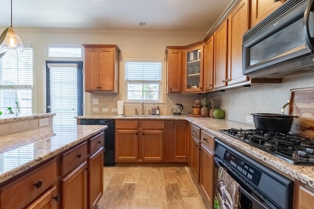 6426 Queens Court Trce Unit 7, Mableton, GA 30126 - kitchen featuring black appliances, brown cabinetry, light wood finished floors, light stone counters, and decorative backsplash