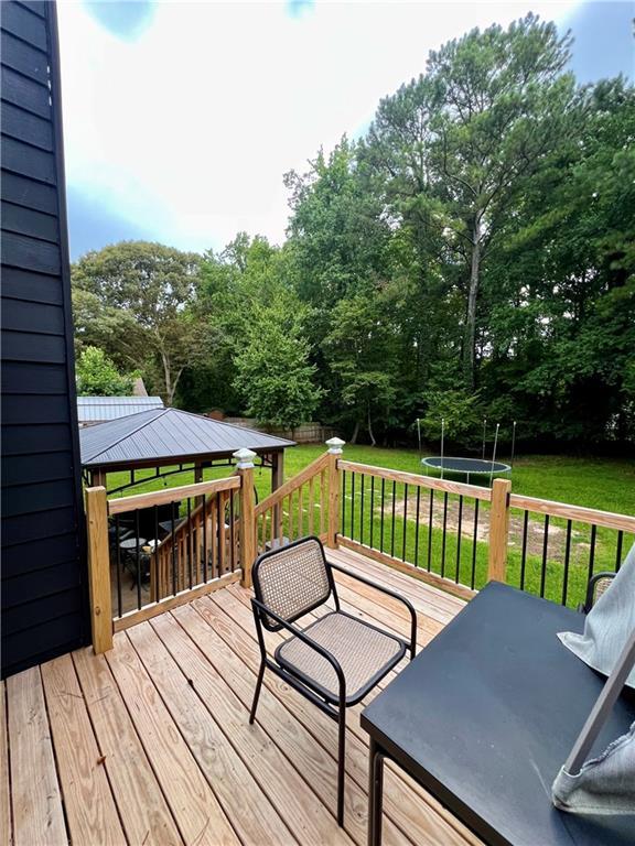 124 Dockside Downs Dr, Woodstock, GA 30189 - wooden terrace with a gazebo, a lawn, and view of wooded area