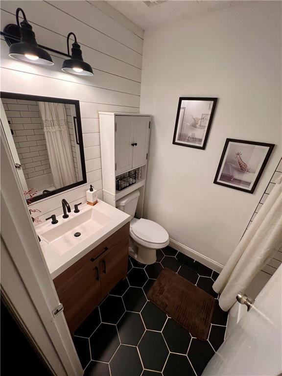 124 Dockside Downs Dr, Woodstock, GA 30189 - bathroom featuring vanity, tile patterned floors, curtained shower, and wood walls