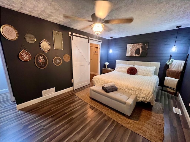 124 Dockside Downs Dr, Woodstock, GA 30189 - bedroom with a barn door, wood finished floors, a ceiling fan, and an accent wall