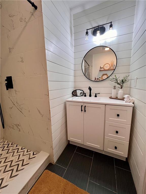 124 Dockside Downs Dr, Woodstock, GA 30189 - bathroom with a shower stall, vanity, tile patterned flooring, and wooden walls