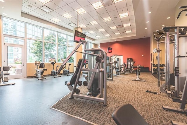 gym with a tray ceiling and a drop ceiling