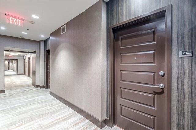 hallway with light hardwood / wood-style floors