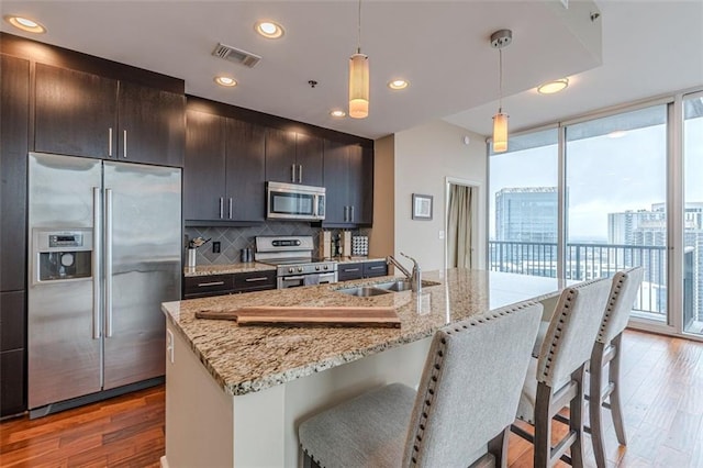 kitchen featuring hanging light fixtures, stainless steel appliances, dark hardwood / wood-style floors, and sink