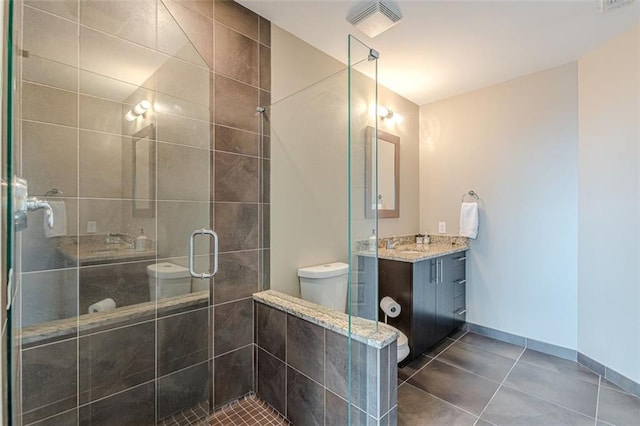 bathroom with tile patterned floors, vanity, an enclosed shower, and toilet