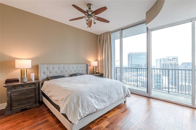 bedroom featuring ceiling fan, floor to ceiling windows, wood-type flooring, and access to outside