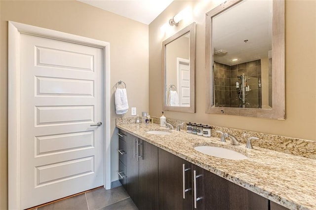 bathroom with tile patterned flooring, vanity, and tiled shower