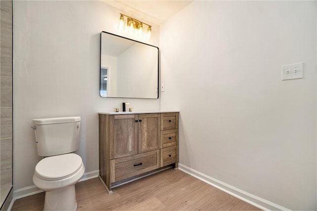 bathroom with toilet, hardwood / wood-style flooring, and vanity