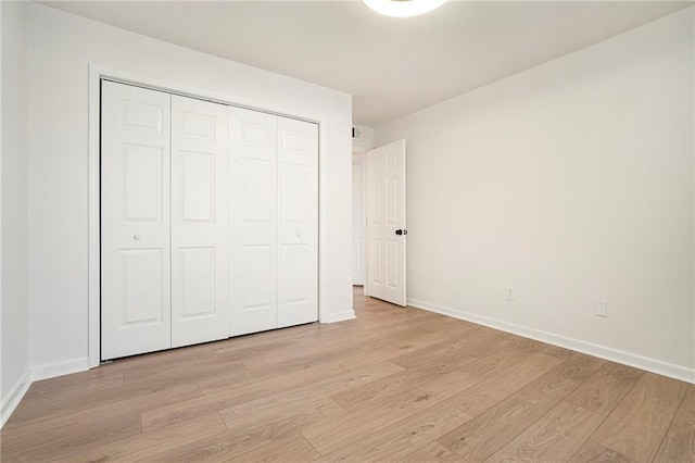 unfurnished bedroom featuring a closet and light wood-type flooring