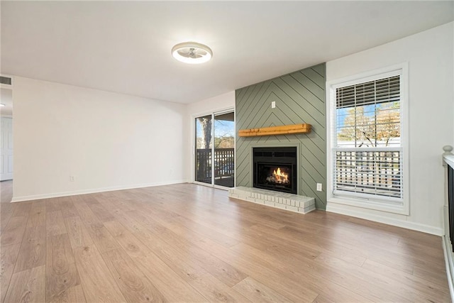 unfurnished living room with light wood-type flooring and a fireplace