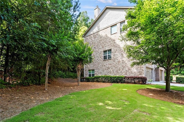 5440 Willow Oak Dr, Norcross, GA 30092 - view of property exterior with a chimney, a garage, a yard, and brick siding