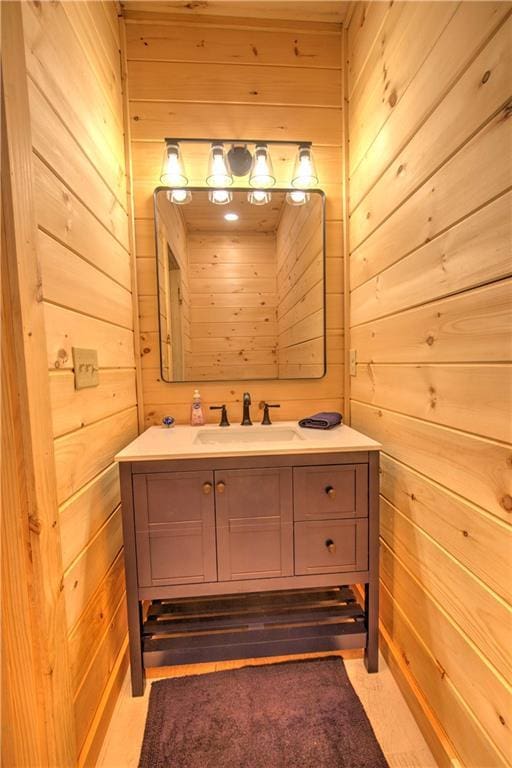 bathroom featuring vanity and wooden walls