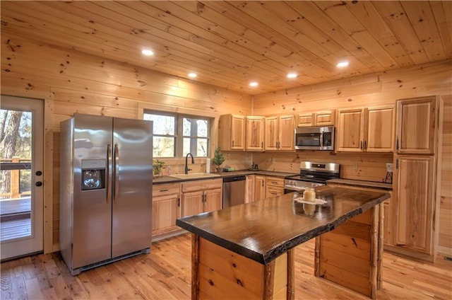 kitchen featuring sink, appliances with stainless steel finishes, light wood-type flooring, and a kitchen island