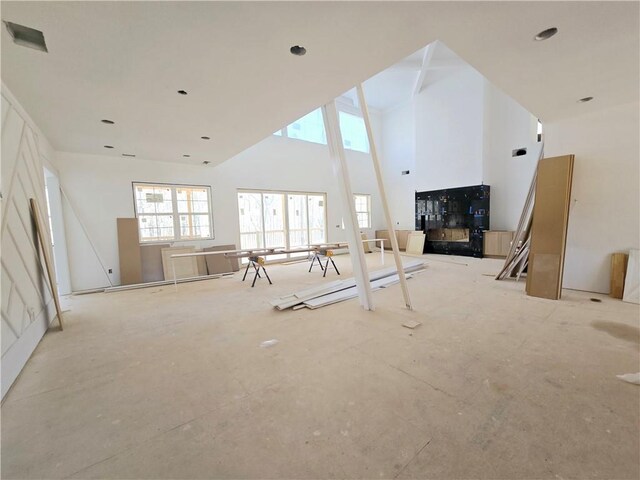 interior space with coffered ceiling, a fireplace, beamed ceiling, and a high ceiling