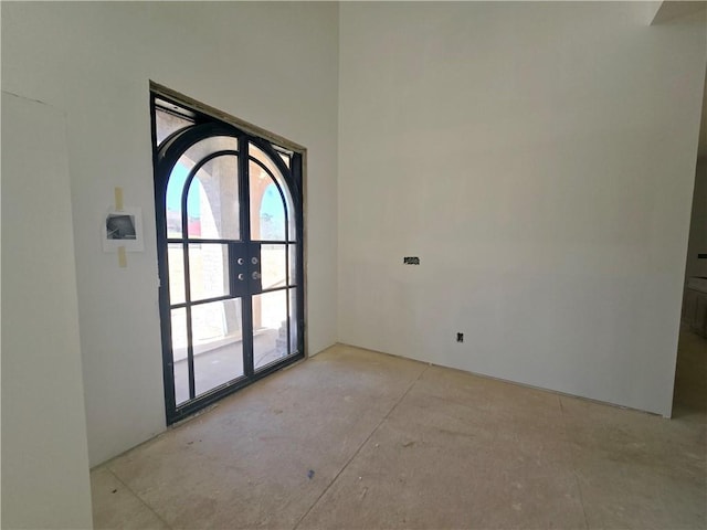 empty room featuring concrete flooring and french doors