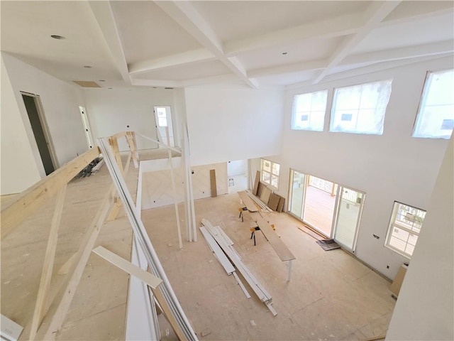 interior space featuring coffered ceiling, plenty of natural light, and beamed ceiling