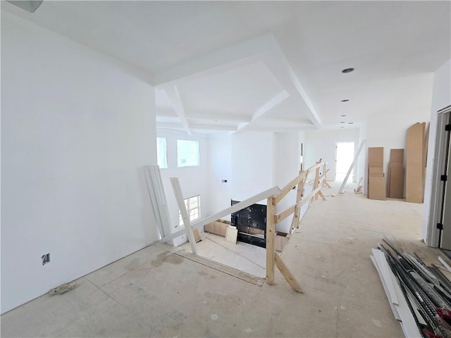 unfurnished room with beam ceiling, coffered ceiling, and a wealth of natural light