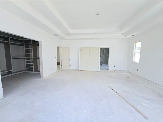 unfurnished bedroom with a raised ceiling